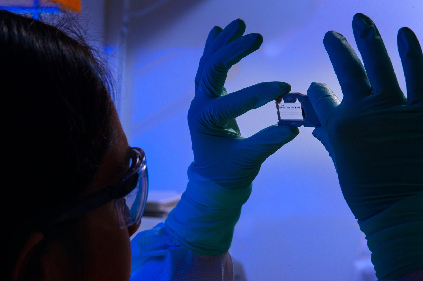 Researcher examining a slide in a lab setting