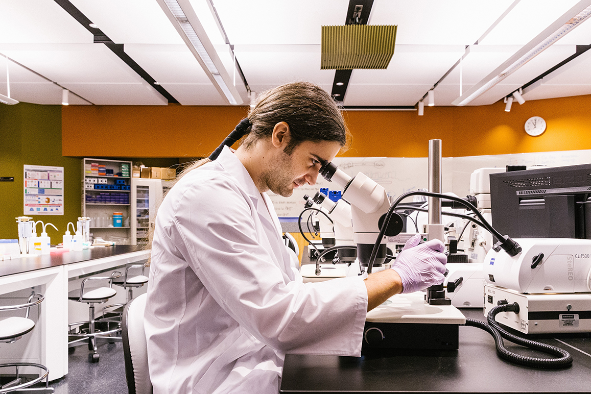 man looking into microscope